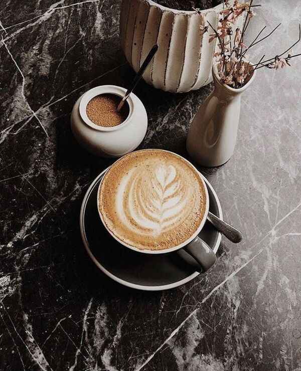 ถ้วยเครื่องดื่มอุ่นบนโต๊ะไม้ในบรรยากาศเรียบง่ายและสบายตา